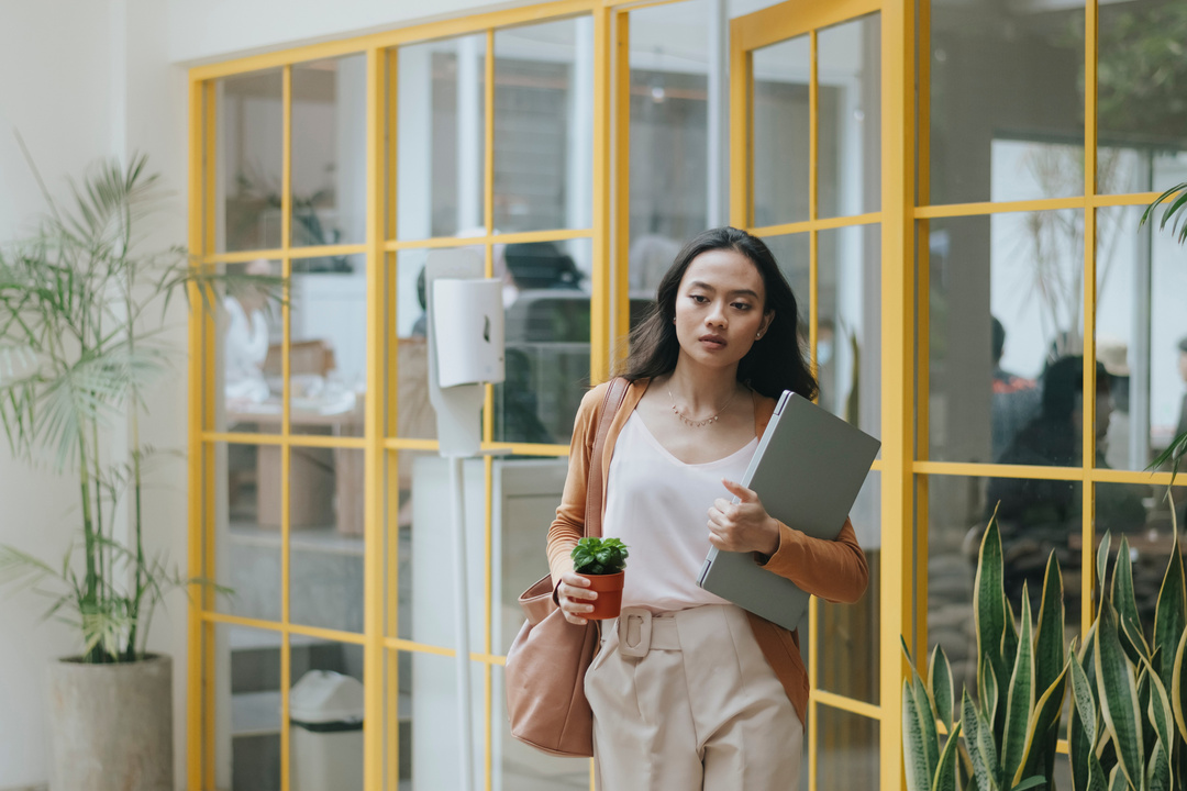 Illustration : image d'une femme sortant d'un bureau avec un ordinateur portable sous le bras